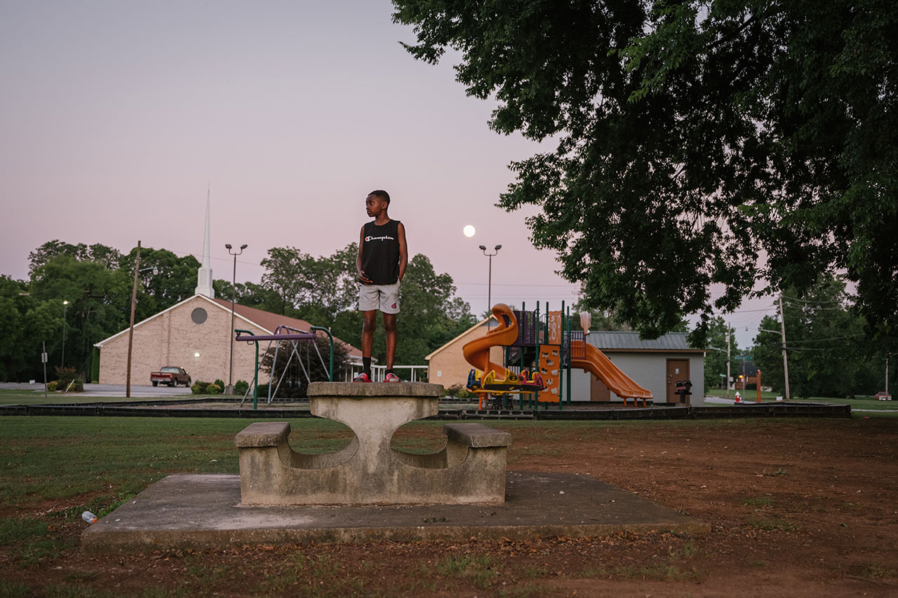 Child stands on a picnic table in Old Town Decatur